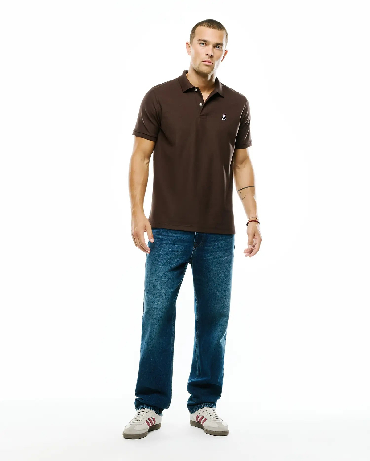 Men's Classic Pima Pique Polo in rich brown, featuring a classic fit, two-button placket, and a small embroidered white Psycho Bunny skull logo on the left chest. (5)