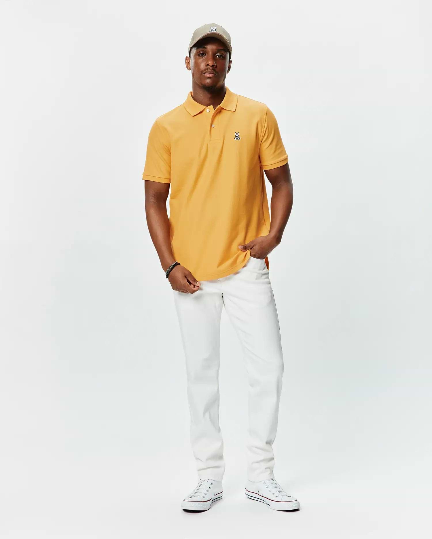 Mens Classic Pique Polo in golden orange, featuring a classic fit, textured pique fabric, and a small, embroidered multi-color Psycho Bunny skull logo on the left chest.