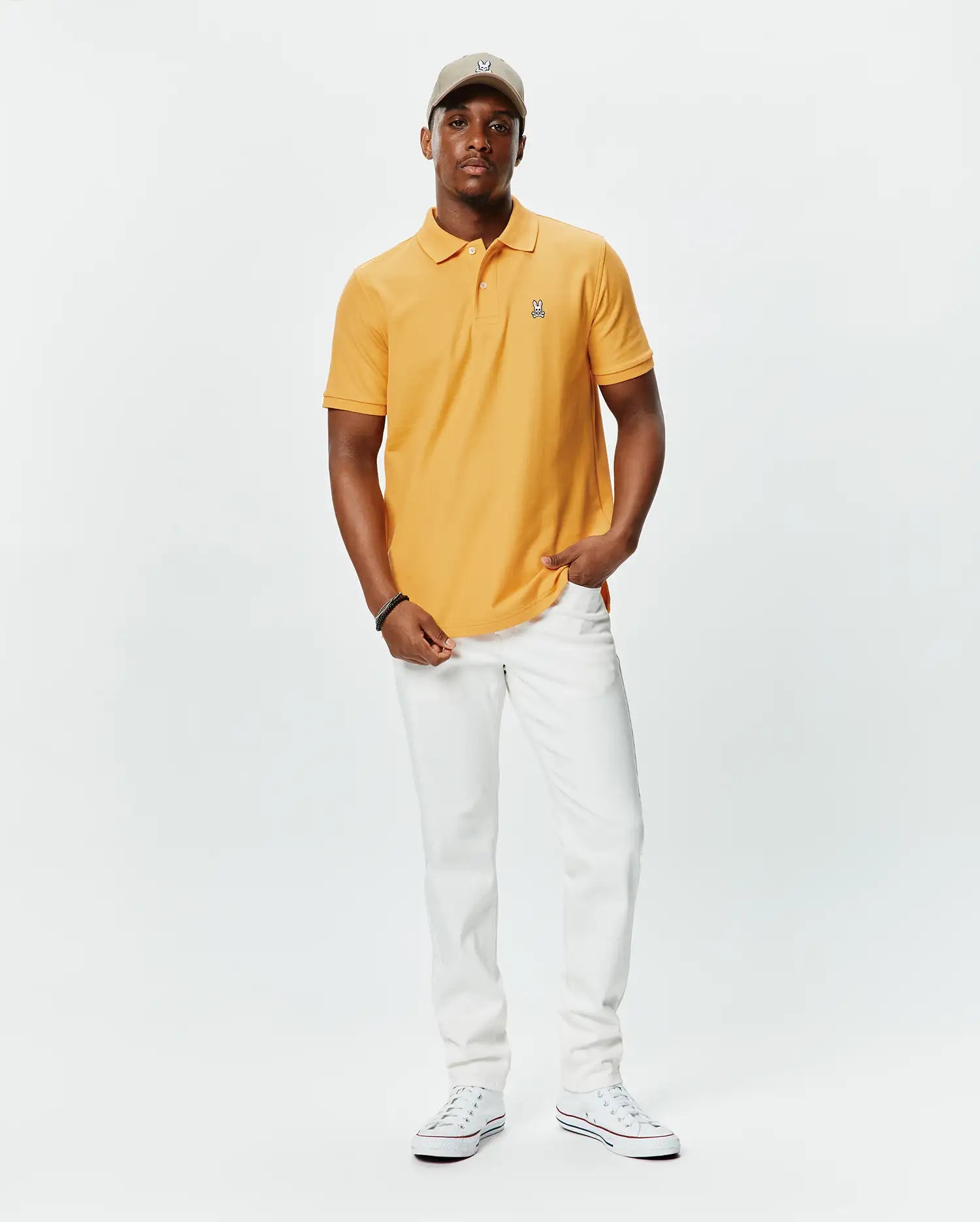 Mens Classic Pique Polo in golden orange, featuring a classic fit, textured pique fabric, and a small, embroidered multi-color Psycho Bunny skull logo on the left chest.