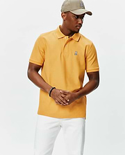 Golden orange pique knit Mens Classic Pique Polo, featuring a classic fit, two-button placket, and a small embroidered white and black Psycho Bunny skull logo on the left chest.