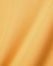 Mens Classic Pique Polo in a rich, sun-kissed golden yellow hue, featuring the signature breathable pique knit texture with visible micro-perforations and soft, flowing fabric folds.