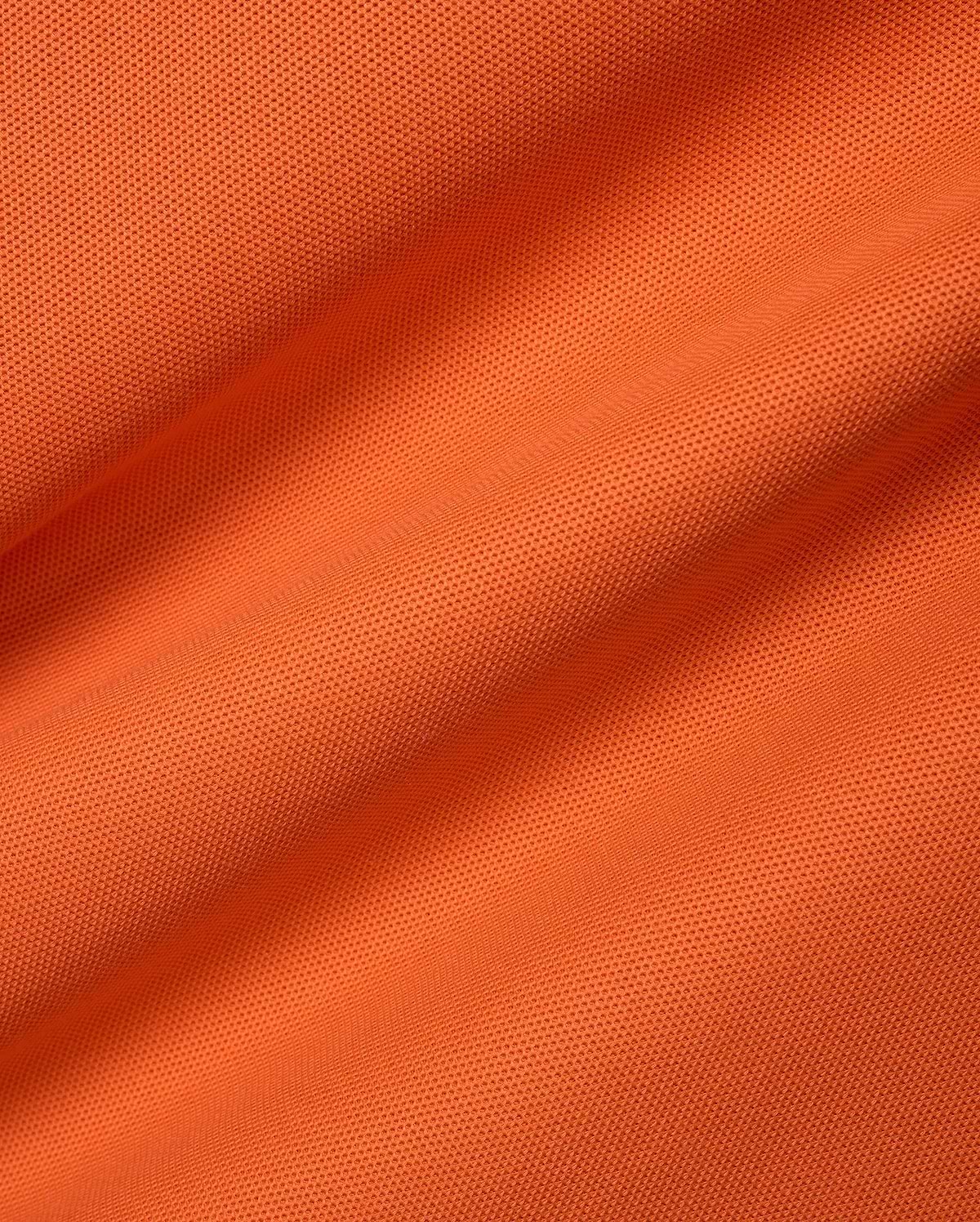 Men's Classic Pima Pique Polo in a bold, vibrant orange hue, meticulously crafted from premium, breathable textured pique fabric, embodying refined streetwear with a classic fit. (6)