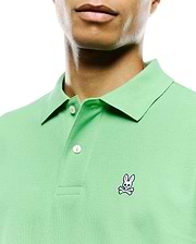 Mens Classic Pique Polo in light green, featuring a classic fit, pique knit texture, two white buttons on the placket, and a small, embroidered pink, white, and black Psycho Bunny skull logo on the left chest. (4)