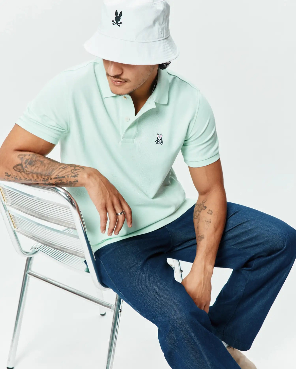 Pale mint green Mens Classic Pique Polo, classic fit, with a two-button placket and small embroidered dark blue and pink Psycho Bunny skull logo on the left chest. (4)