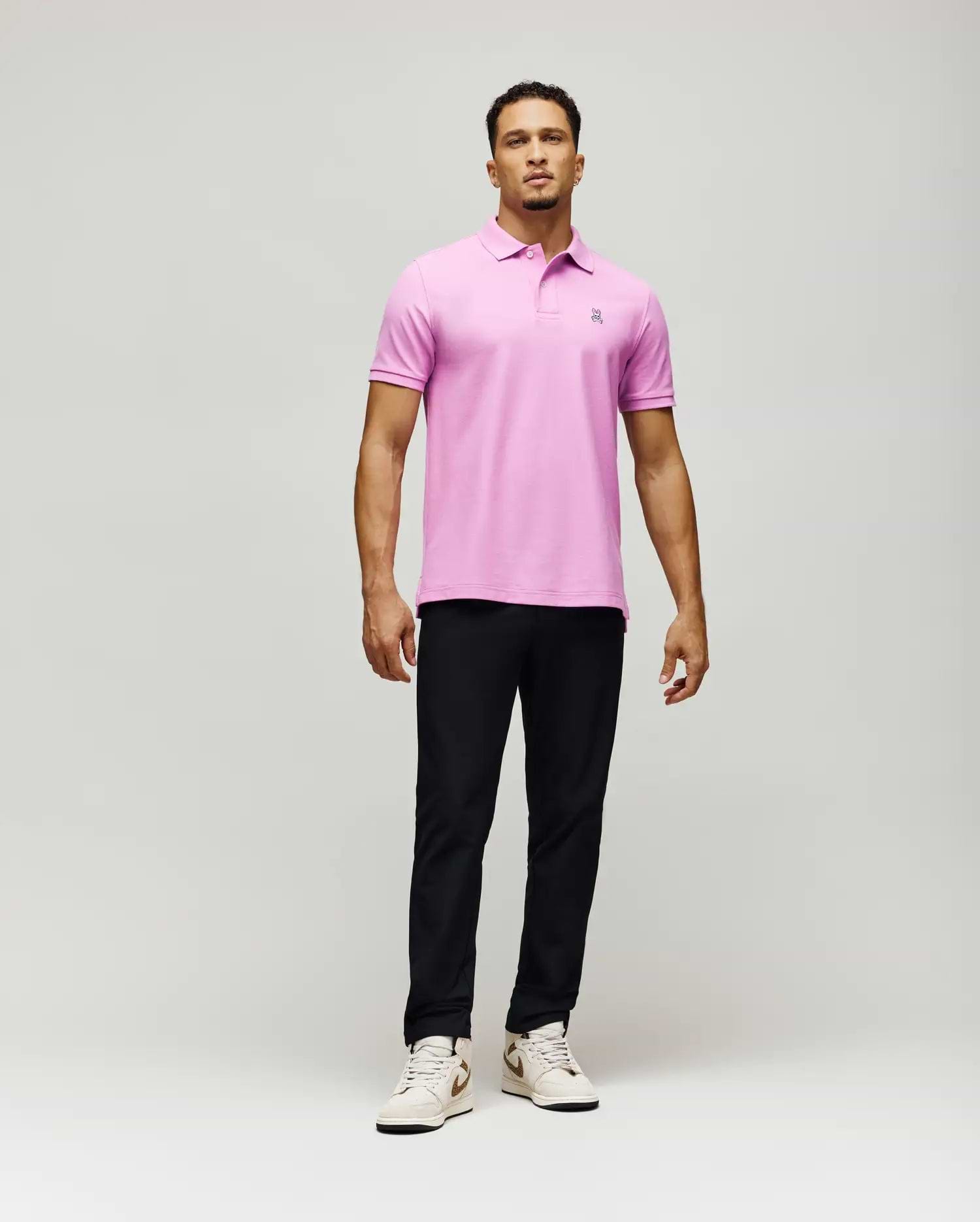 Mens Classic Pique Polo, a vibrant pink classic fit polo shirt crafted from textured pique fabric, featuring a small, intricately embroidered Psycho Bunny skull logo on the left chest.