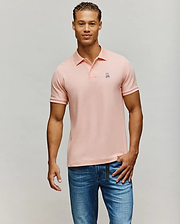Mens Classic Pique Polo in light pink, featuring a classic fit, two-button placket, and a small embroidered white and black Psycho Bunny skull logo on the left chest.
