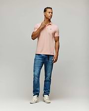 Mens Classic Pique Polo in soft peach, a classic fit shirt crafted from textured pique fabric, featuring a small, iconic embroidered Psycho Bunny skull logo on the left chest with white, black, and red details.