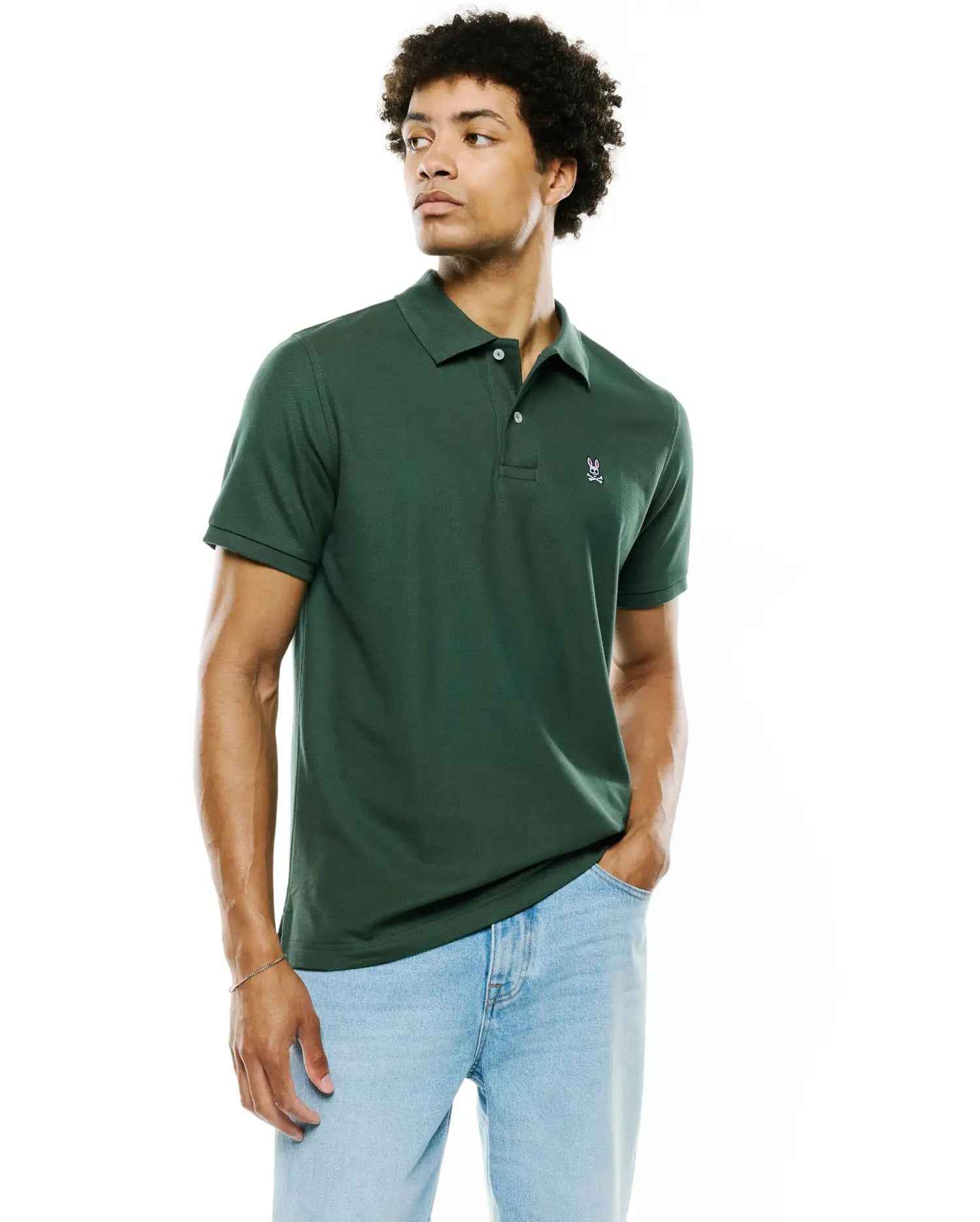 Mens Classic Pique Polo in deep green pique knit, classic fit, with a small embroidered Psycho Bunny skull logo on the left chest and white buttons.