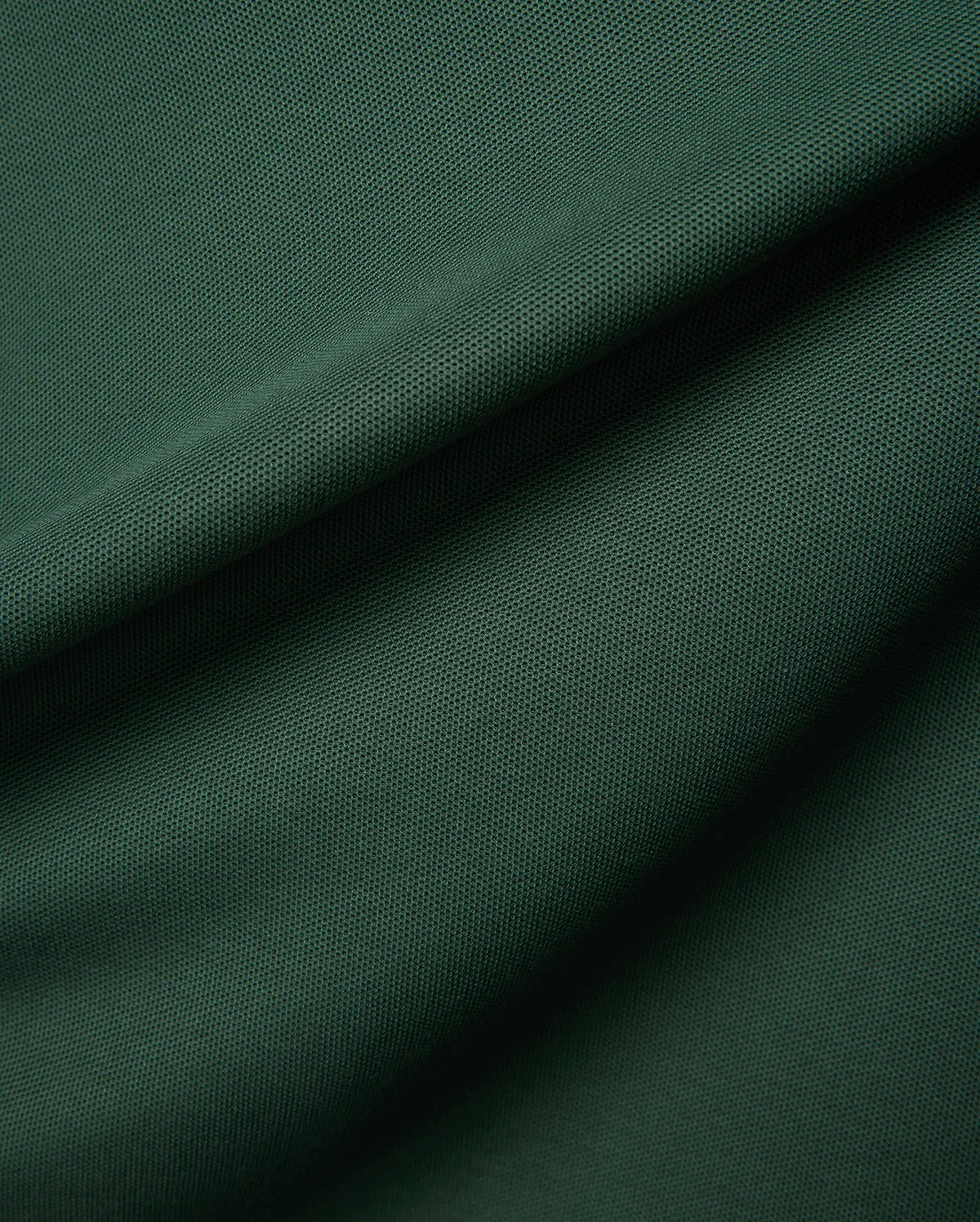 Mens Classic Pique Polo in a deep forest green, highlighting the refined, textured pique fabric with elegant folds, embodying Psycho Bunny's premium streetwear.