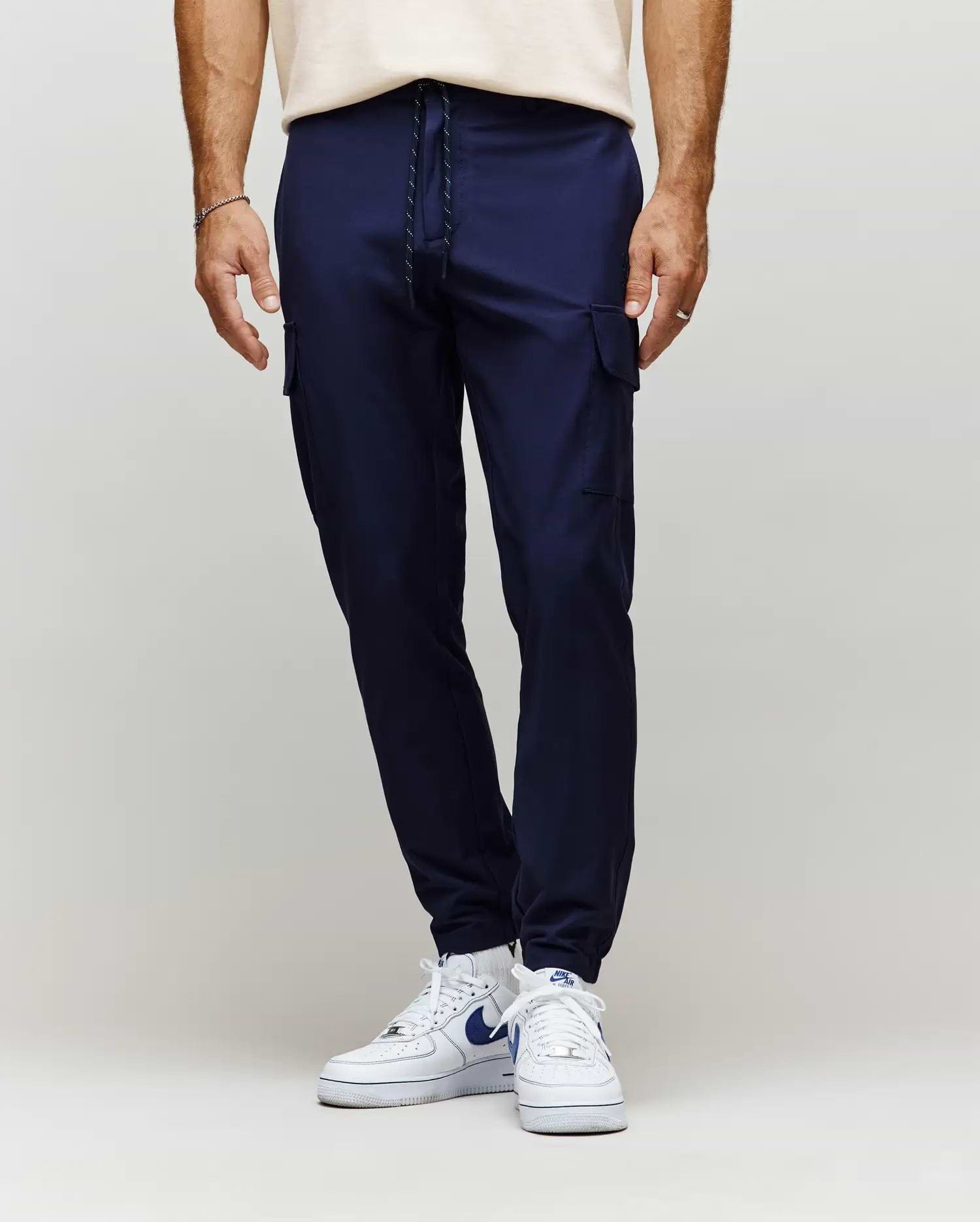 Mens Lloyd Cargo Jogger in navy blue, featuring a slim, tapered fit, smooth fabric, side cargo pockets, and a black and white drawstring waist with ribbed cuffs.