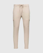 The MENS LLOYD CARGO JOGGER - B6P159B200 by Psycho Bunny is a pair of slim-fit beige cargo jogger pants, featuring tapered legs, an elastic waistband with a drawstring, two side pockets, and two cargo pockets on the thighs. These joggers are adorned with a subtle silicone branded detail.
