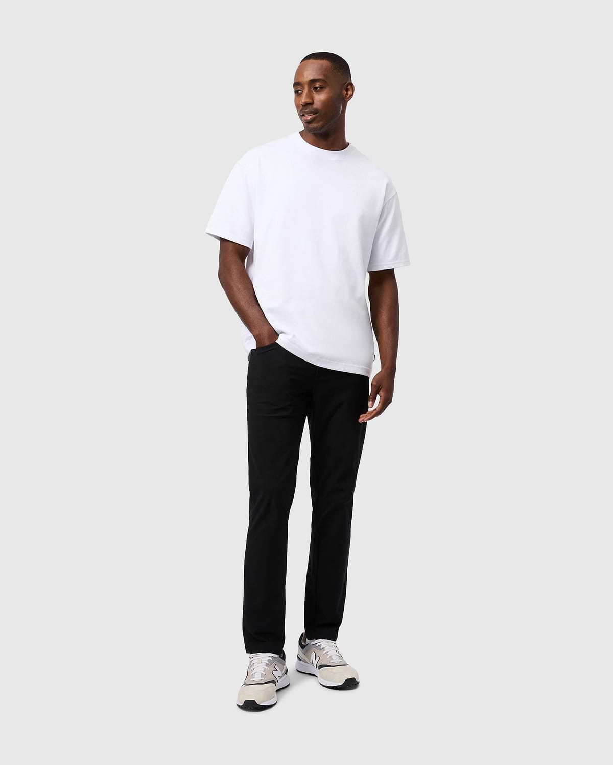 White relaxed-fit jersey t-shirt with a small embroidered Psycho Bunny logo on the left chest, paired with black slim-fit Mens Maverick 10k Step Pant 31 1/2 L.