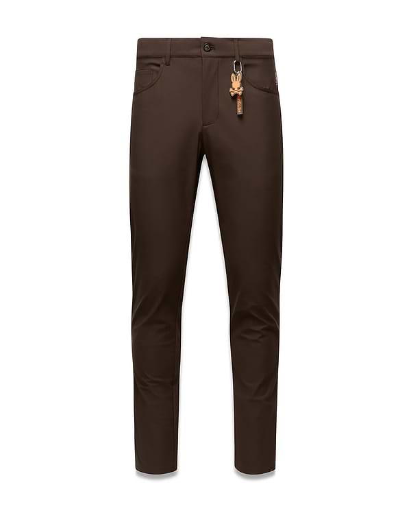 Brown Mens Maverick 10k Step Pant, slim fit, featuring a small red embroidered Psycho Bunny logo on the right front pocket and a prominent brown and orange skull keychain on the left belt loop.