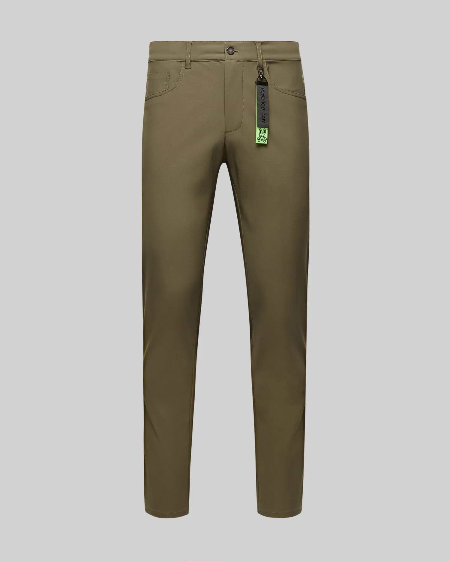 The Psycho Bunny MENS MAVERICK 10K STEP PANT - B6P788D200 in olive green is shown front-facing on a gray background, with slim fit, button and zipper closure, five pockets, belt loops, and a black tag with green accents on the belt loop.
