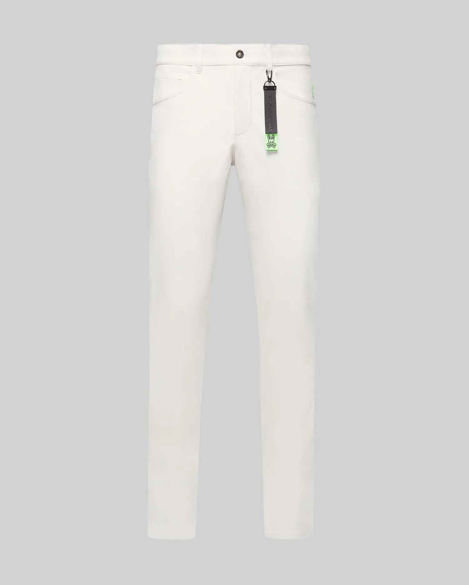 Mens Maverick 10k Step Pant in white, featuring a straight fit, smooth fabric, and a small embroidered neon green Psycho Bunny skull logo on the right hip. A black and neon green branded keychain hangs from a belt loop.