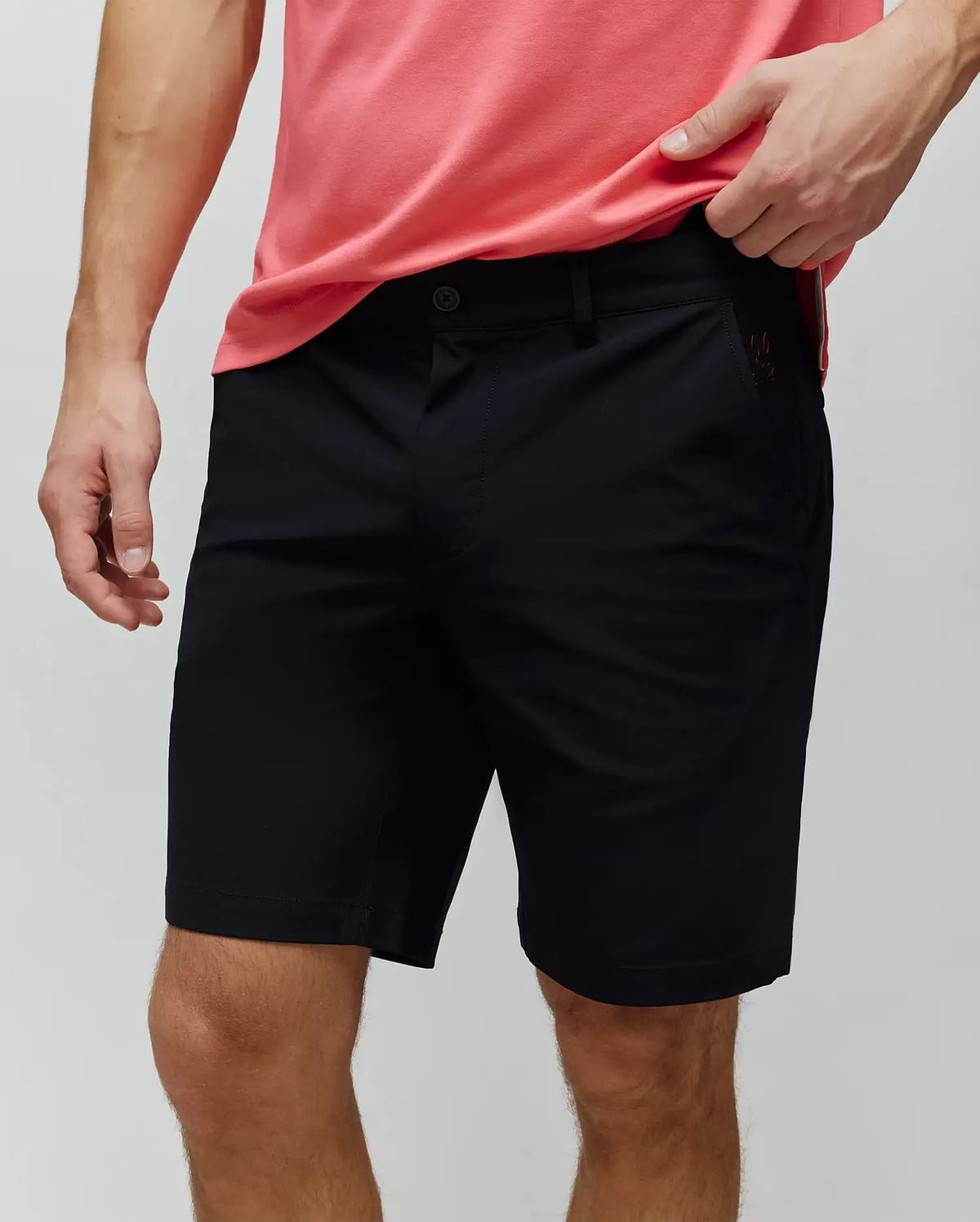 Mens Maverick 10k Step Short, classic fit black shorts made from smooth fabric, featuring a flat front, button closure, belt loops, and a small, tonal embroidered Psycho Bunny skull logo on the right front pocket.
