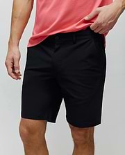 Mens Maverick 10k Step Short, classic fit black shorts made from smooth fabric, featuring a flat front, button closure, belt loops, and a small, tonal embroidered Psycho Bunny skull logo on the right front pocket.