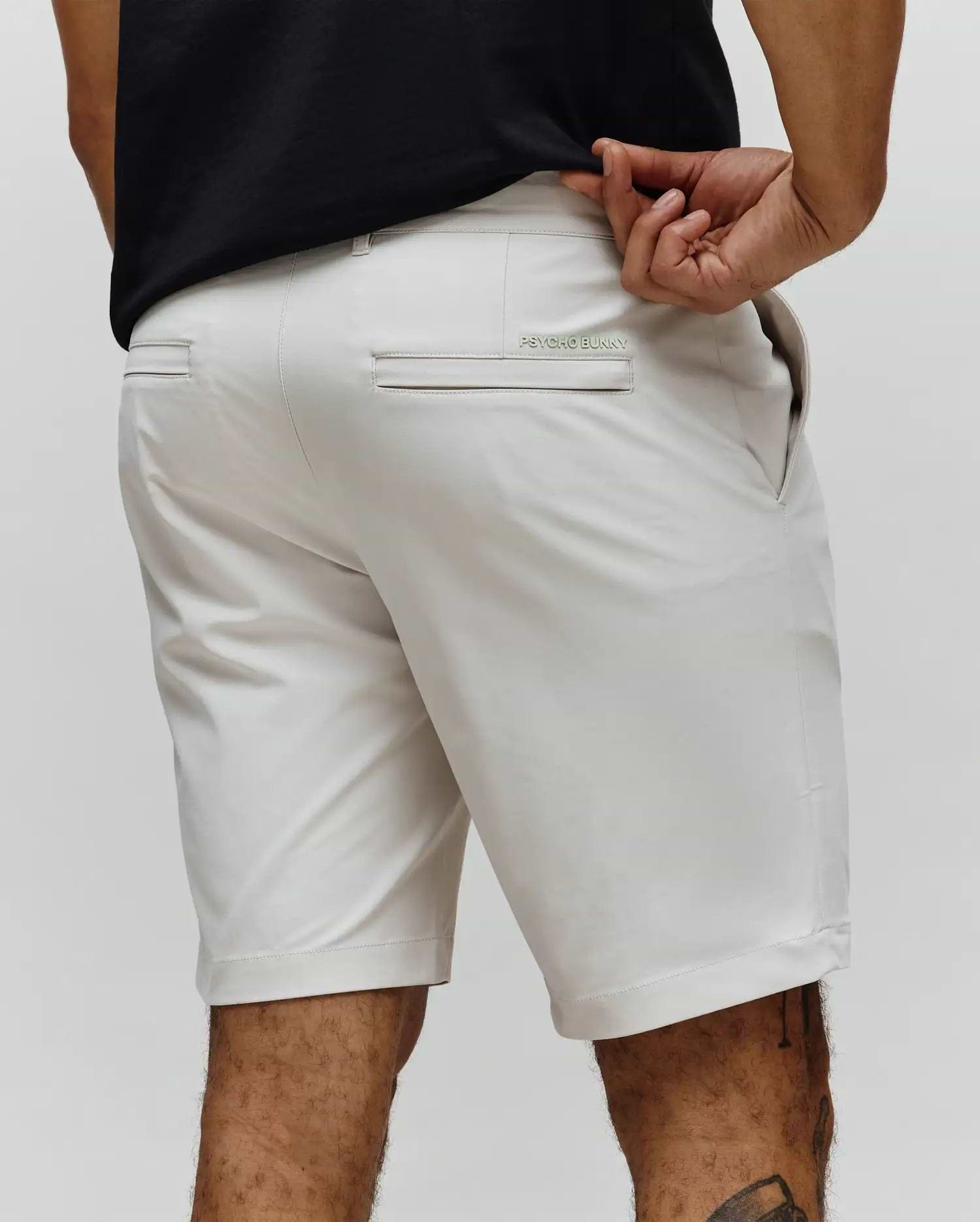 Mens Maverick 10k Step Short in stone, featuring a classic fit and smooth performance fabric. Small mint green embroidered Psycho Bunny text logo on the back right welt pocket.