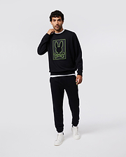 Mens Los Angeles Fleece Sweatshirt in black, featuring a relaxed fit and soft fleece texture, with a bold neon green outlined Psycho Bunny skull and crossbones logo graphic on the chest.