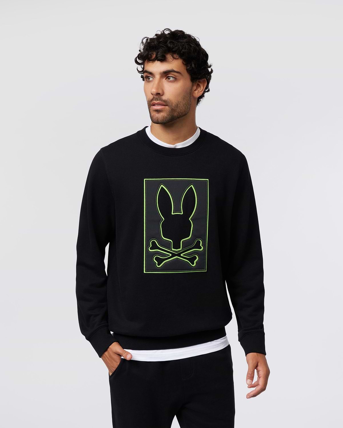 Mens Los Angeles Fleece Sweatshirt in black, featuring a large, centered neon green outline of the Psycho Bunny skull logo on a black patch, classic fit, soft fleece texture.