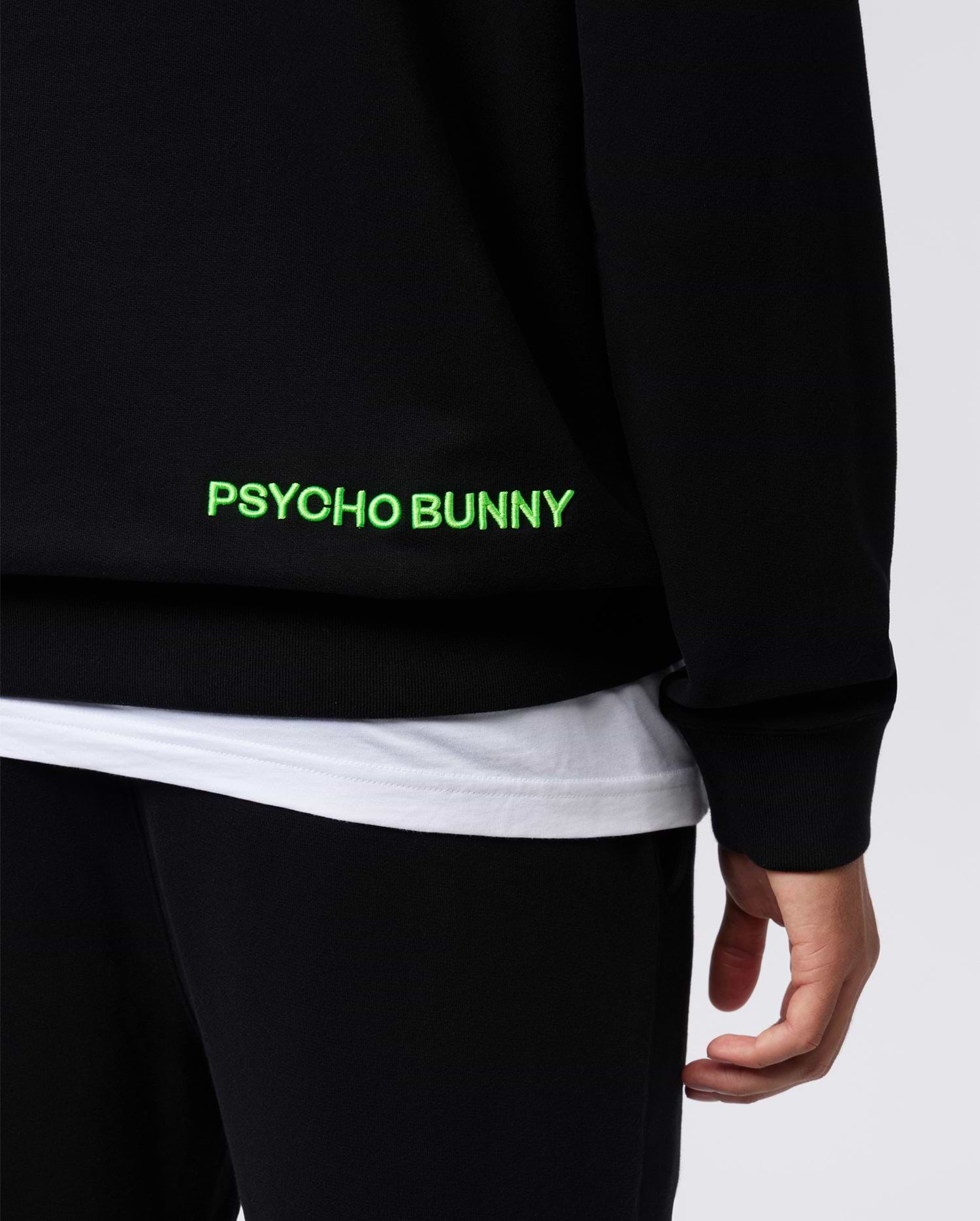 Black Mens Los Angeles Fleece Sweatshirt, relaxed fit, soft fleece texture, featuring a large neon green embroidered PSYCHO BUNNY text logo on the lower side.