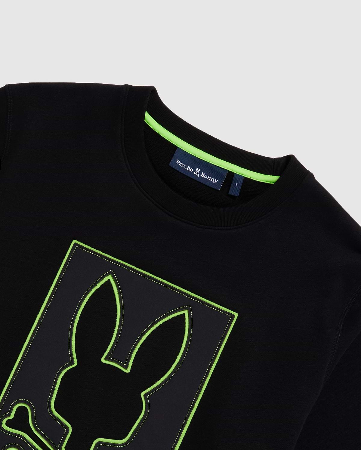 Mens Los Angeles Fleece Sweatshirt, black with a large central embroidered Psycho Bunny skull logo featuring a neon green outline and contrast stitching. Classic fit, soft fleece, and neon green neck tape.