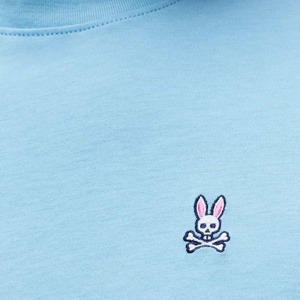 Mens Classic Crew Neck Tee in light blue jersey knit, featuring a small embroidered Psycho Bunny skull logo with pink ears on the left chest, classic fit.