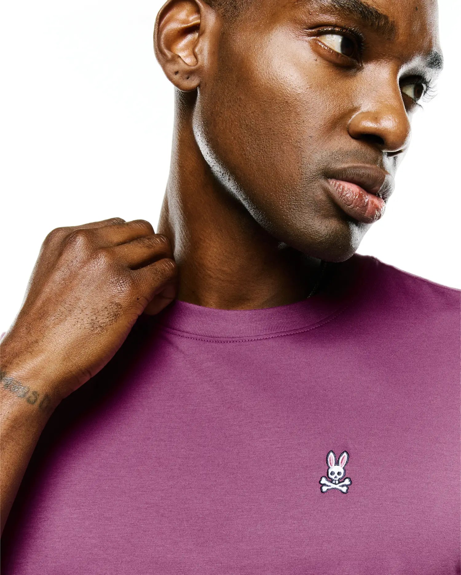 Mens Classic Crew Neck Tee in plum, featuring a smooth jersey knit and a small, embroidered white, black, and pink Psycho Bunny skull logo on the left chest.