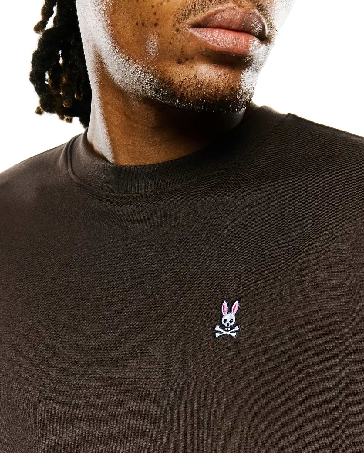 Men's Classic Pima Crew Neck Tee in dark brown jersey, featuring a small embroidered Psycho Bunny skull logo with pink ears on the left chest, offering a classic fit. (3)
