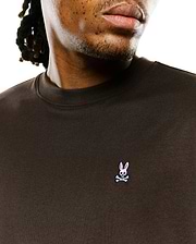 Men's Classic Pima Crew Neck Tee in dark brown jersey, featuring a small embroidered Psycho Bunny skull logo with pink ears on the left chest, offering a classic fit. (3)
