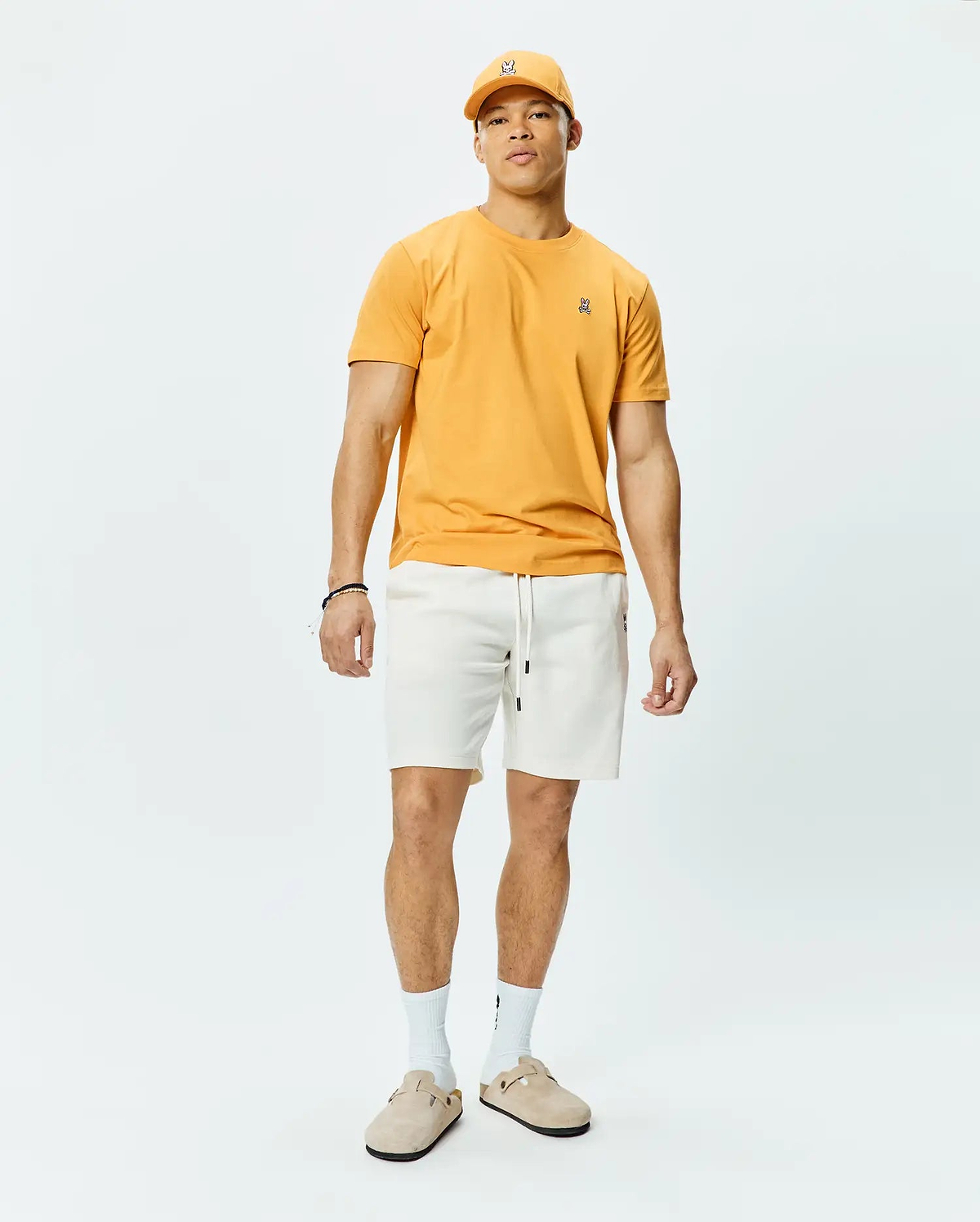 Mustard Yellow Mens Classic Crew Neck Tee in soft jersey knit, featuring a classic fit and a small embroidered black and white Psycho Bunny skull logo on the left chest.