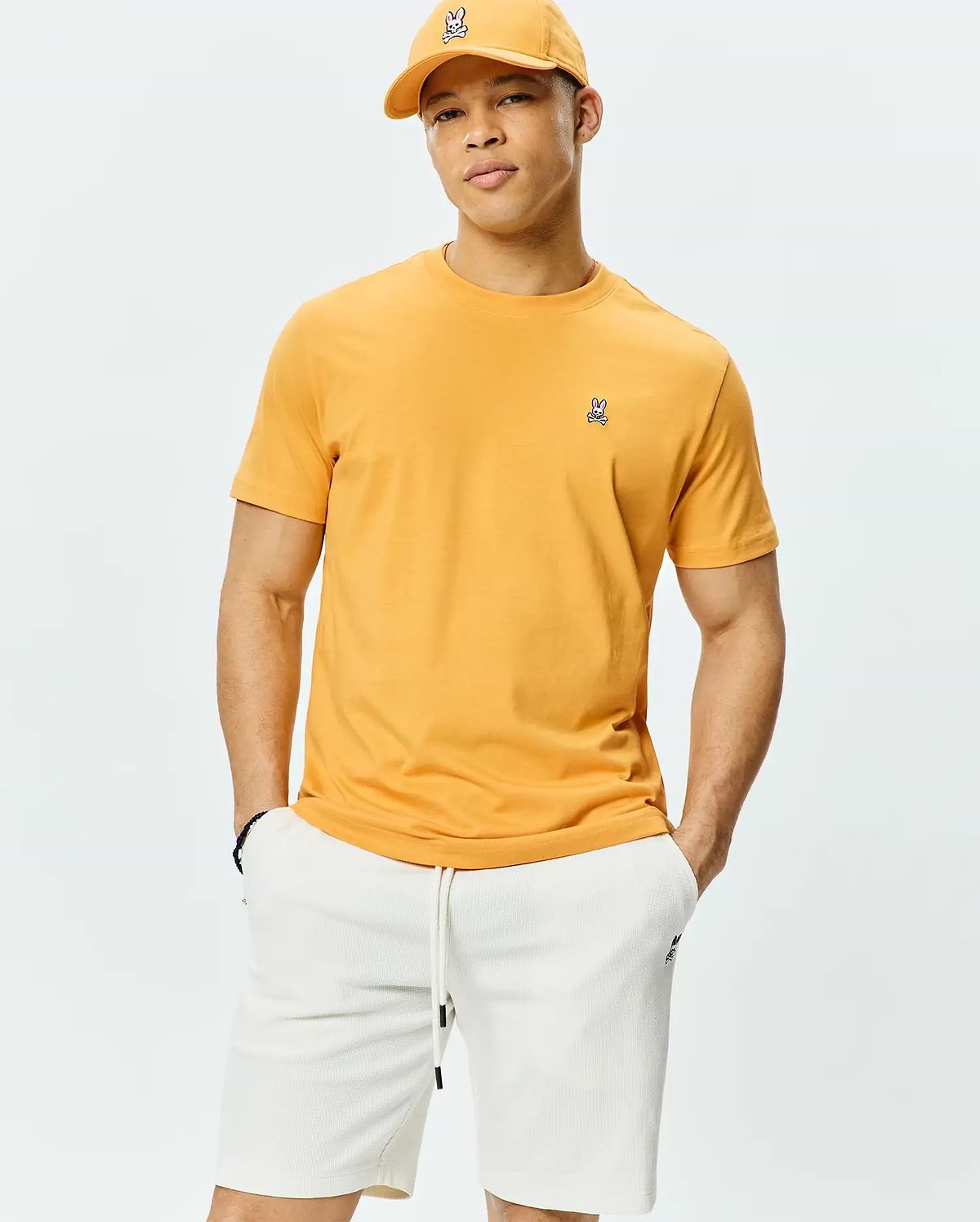 Mens Classic Crew Neck Tee in bold golden yellow, crafted from soft jersey knit with a classic fit, featuring a small, signature embroidered Psycho Bunny skull logo on the left chest.