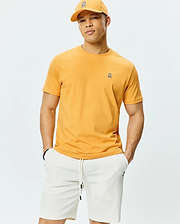 Mens Classic Crew Neck Tee in bold golden yellow, crafted from soft jersey knit with a classic fit, featuring a small, signature embroidered Psycho Bunny skull logo on the left chest.