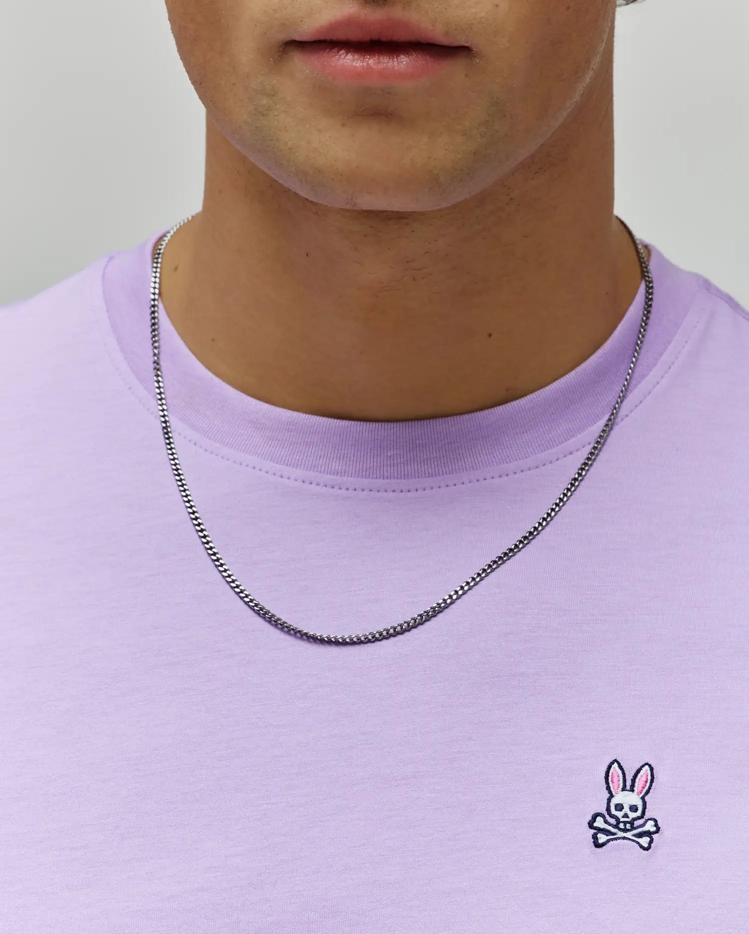 Mens Classic Crew Neck Tee in lavender jersey knit, featuring a classic fit and a small embroidered Psycho Bunny skull logo with pink ears on the left chest.