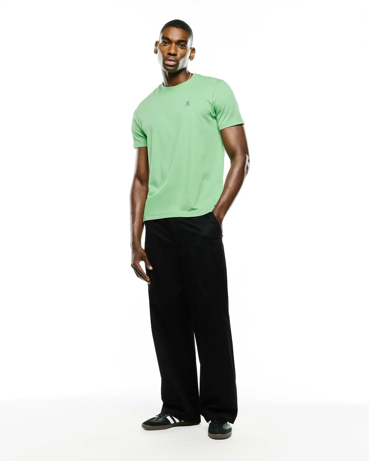 Men's Classic Pima Crew Neck Tee in light green, featuring a classic fit and smooth Pima cotton jersey fabric. A small, embroidered dark blue Psycho Bunny skull logo is on the left chest.