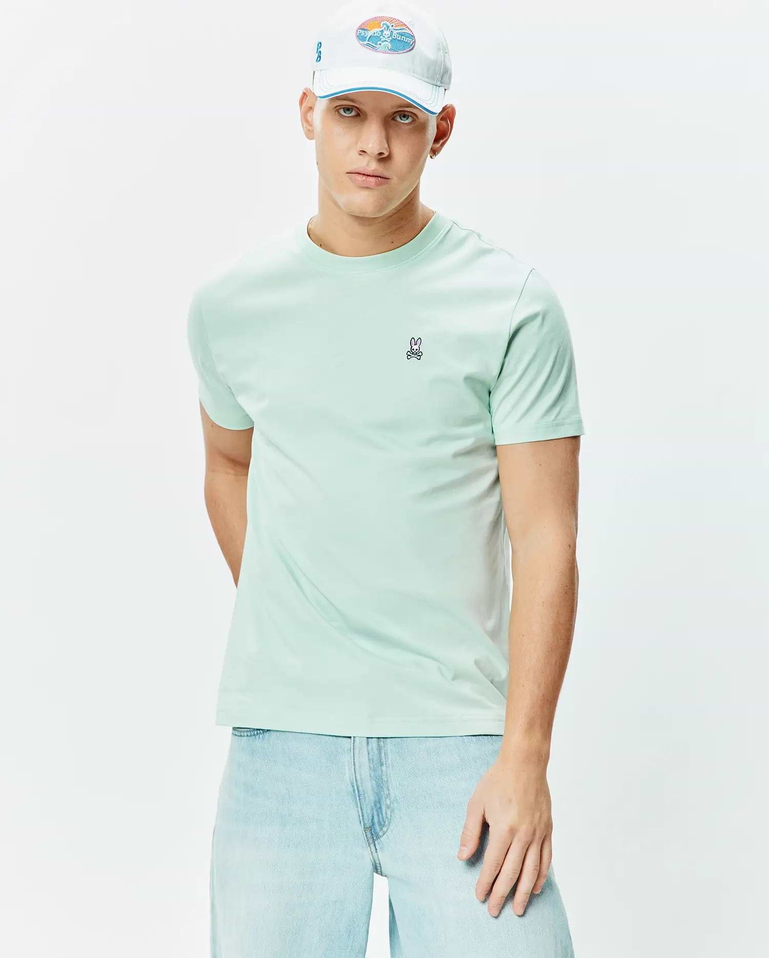 Mens Classic Crew Neck Tee in a vibrant mint green, crafted from soft jersey fabric, featuring a small embroidered black, white, and pink Psycho Bunny skull logo on the left chest, offering a classic fit.