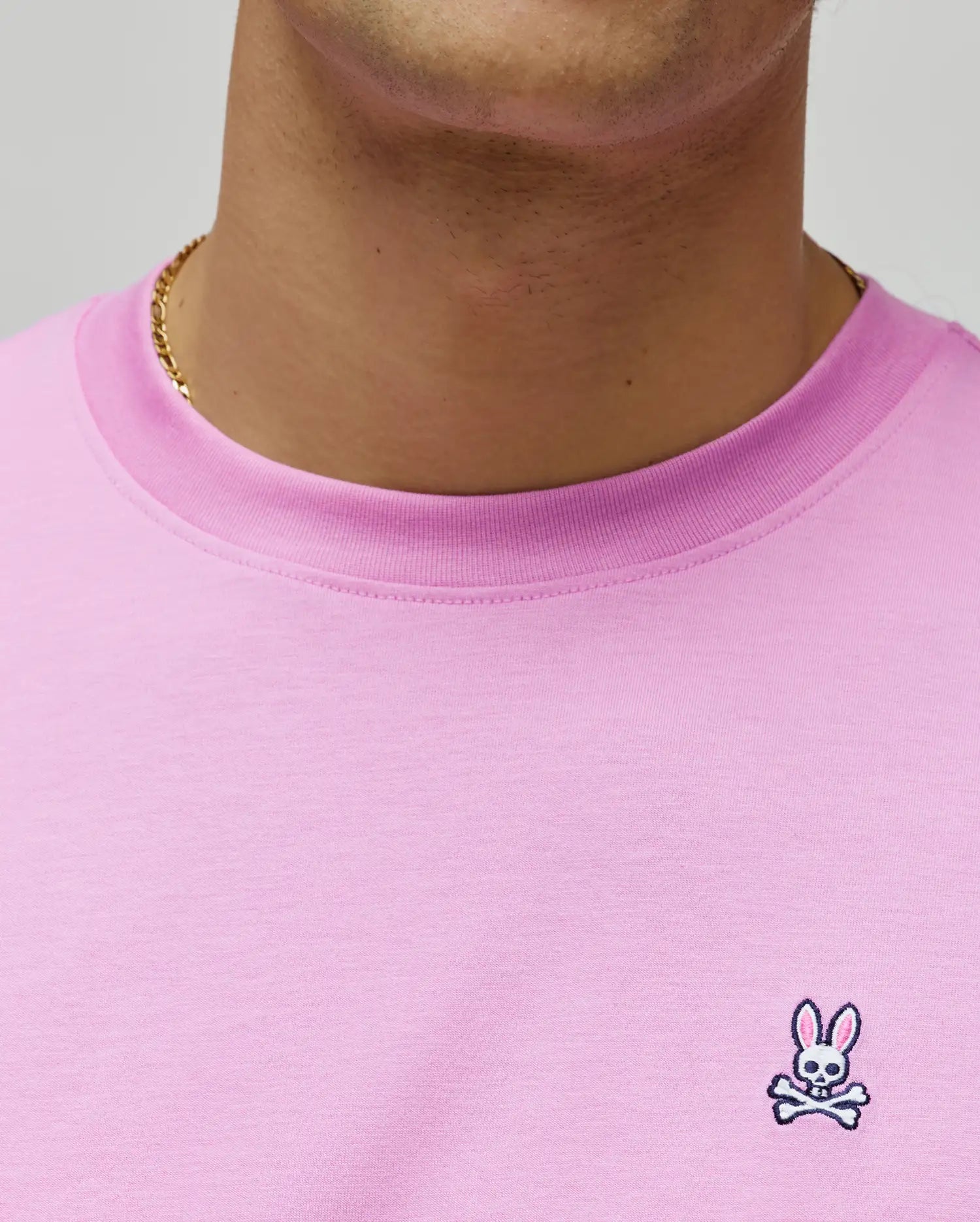 Mens Classic Crew Neck Tee in vibrant pink jersey knit, featuring a classic fit and a small, intricately embroidered Psycho Bunny skull logo on the left chest with white and black details.
