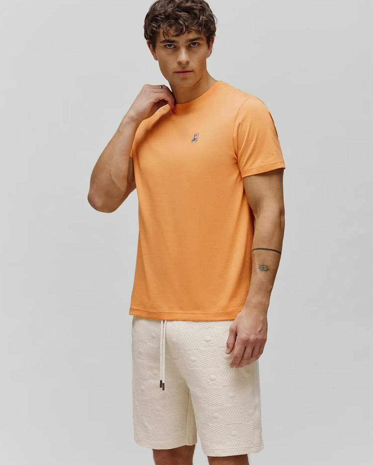 Mens Classic Crew Neck Tee in vibrant orange, featuring a classic fit and smooth jersey fabric, with a small embroidered Psycho Bunny skull logo on the left chest.
