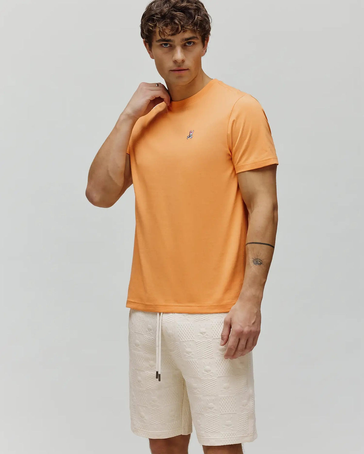 Mens Classic Crew Neck Tee in vibrant orange, featuring a classic fit and smooth jersey fabric, with a small embroidered Psycho Bunny skull logo on the left chest.