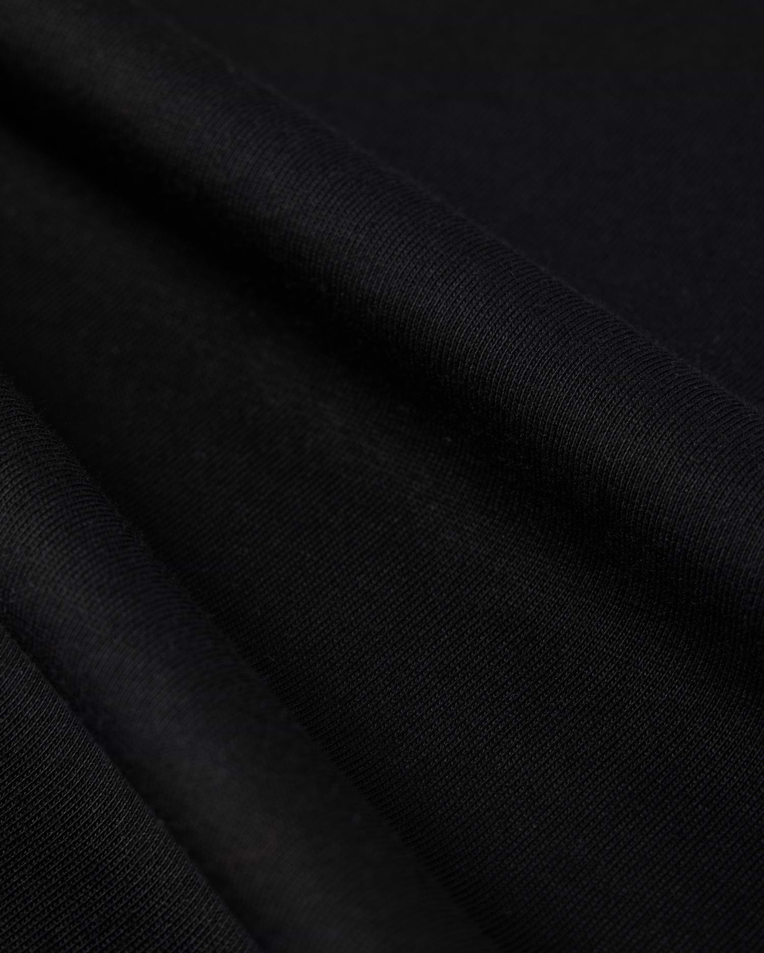 Close-up photo of textured Psycho Bunny Peruvian Pima cotton fabric, showcasing the fine weave and detail of the material.