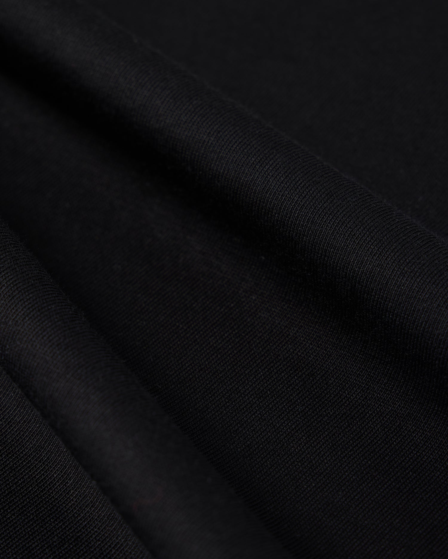 Close-up photo of textured Psycho Bunny Peruvian Pima cotton fabric, showcasing the fine weave and detail of the material.