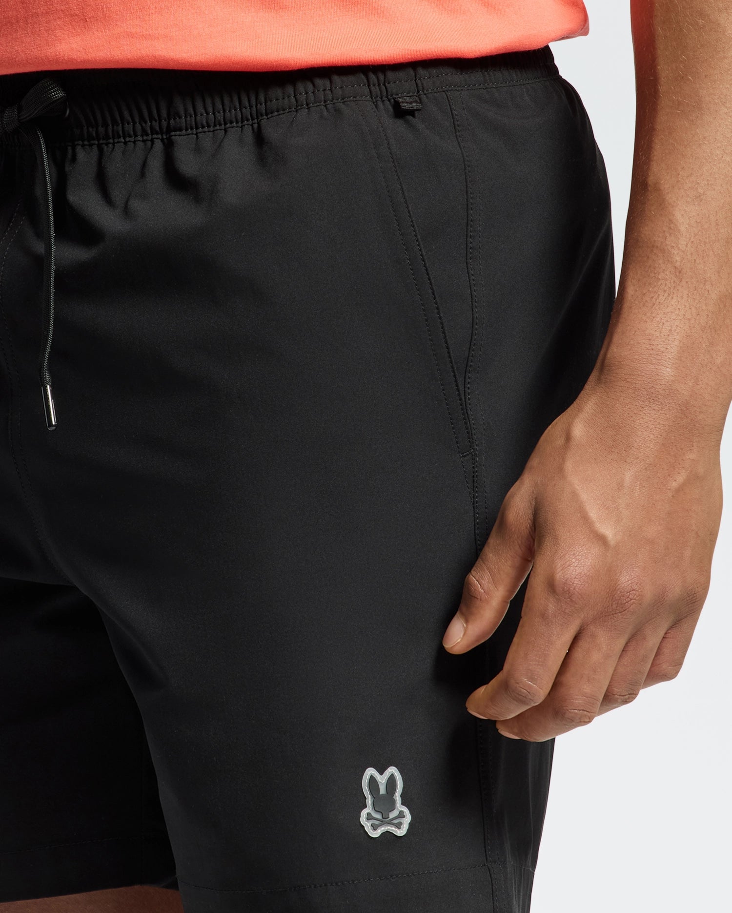 Black Mens Samos Hydrochromic Printed Swim Trunk with a relaxed fit, smooth quick-dry fabric, drawstring waist, side pockets, and a small silver embroidered Psycho Bunny skull logo on the lower left leg.