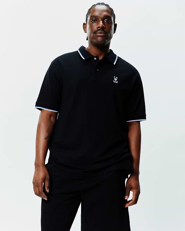 Black Big And Tall Sunny Pique Polo, classic fit, pique knit, with white and light blue tipping on collar and sleeve cuffs, and a small embroidered white Psycho Bunny skull logo on the left chest.