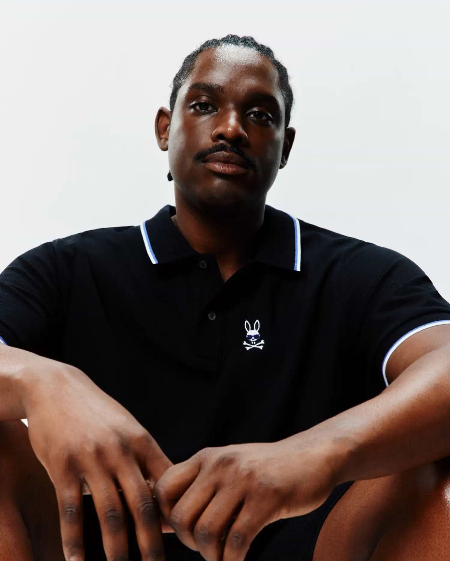 Big And Tall Sunny Pique Polo in black, classic fit, with white and blue tipping on the collar and cuffs. Features a small, embroidered Psycho Bunny skull logo with blue sunglasses on the left chest.
