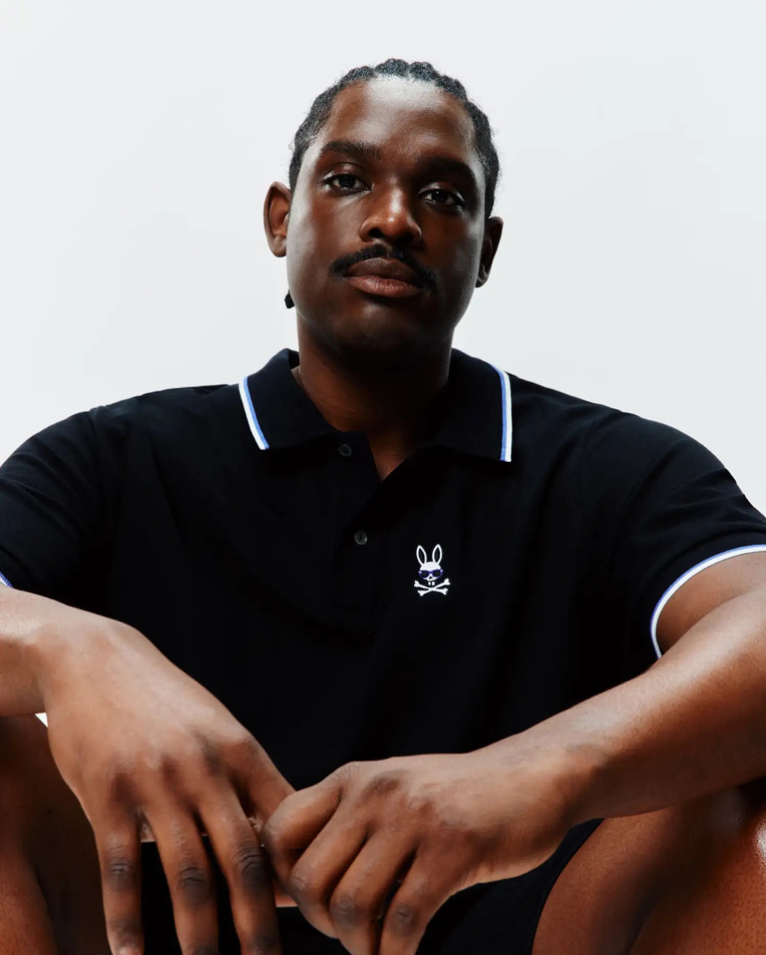 Big And Tall Sunny Pique Polo in black, classic fit, with white and blue tipping on the collar and cuffs. Features a small, embroidered Psycho Bunny skull logo with blue sunglasses on the left chest.