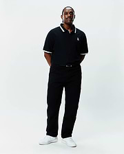 Mens Big And Tall Holden Pique Polo in black pique with white tipping on the collar and cuffs, featuring a small embroidered white Psycho Bunny skull logo on the left chest.