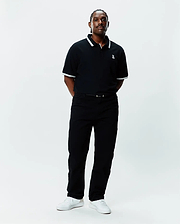 Mens Big And Tall Holden Pique Polo in black pique with white tipping on the collar and cuffs, featuring a small embroidered white Psycho Bunny skull logo on the left chest.