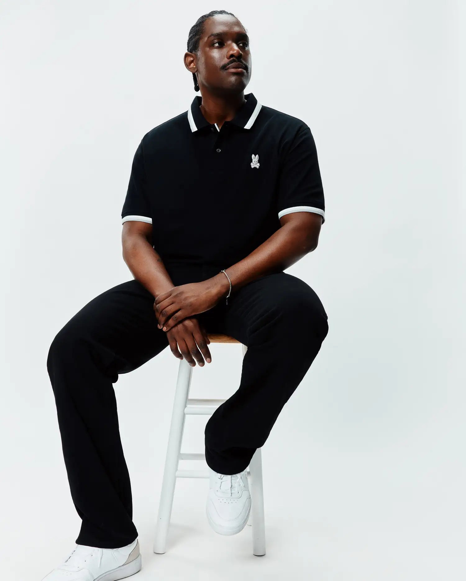 Mens Big And Tall Holden Pique Polo in black, featuring a classic fit, pique texture, white tipping on the collar and sleeve cuffs, and a small white embroidered Psycho Bunny skull logo on the left chest.
