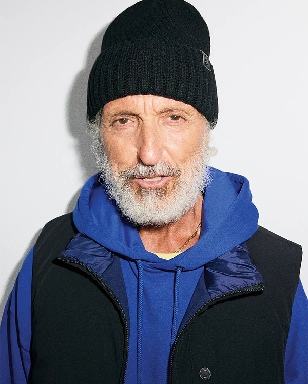 Black ribbed knit MENS BROGAN BEANIE with a subtle bunny skull logo patch, layered over a royal blue relaxed fit french terry hoodie and a black full-zip vest with a dark blue collar and branded snap button.