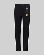 The Psycho Bunny KIDS MATHIEU COMMUTER PANT (KB0600002) features a black, straight-leg classic fit with a button and zip fly, elastic waistband, and a black tag with brown accent on the belt loop. Minimalist design shown on gray background.